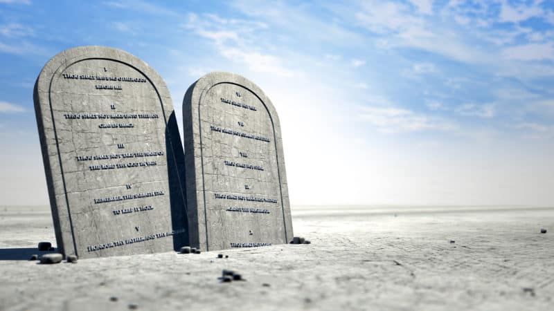 The ten commandments on brown desert sand.